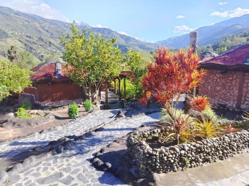 un giardino con un sentiero in pietra, alberi ed edifici di Bella Vista Suites Mérida a Tabay