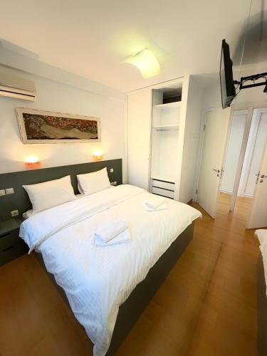 a bedroom with a large bed with two towels on it at Premium Seafront Suite in Thessaloniki