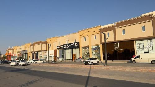 eine Straße mit Autos, die vor den Gebäuden geparkt sind in der Unterkunft Self-occupied apartment 1 in Al Kharj