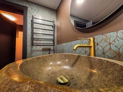 a bathroom with a large sink and a mirror at Telšiai Modern Central Apartments in Telšiai