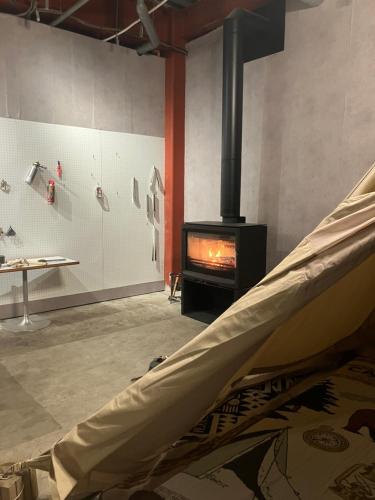 a living room with a stove and a couch at 川辺-kawabe 悠- 川遊び-BBQ in Hanno
