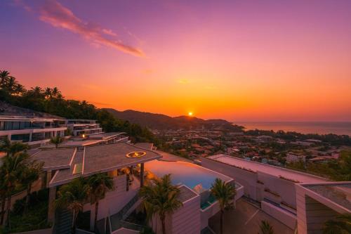 a sunset over the ocean from a building at The Seaview Kata in Kata Beach