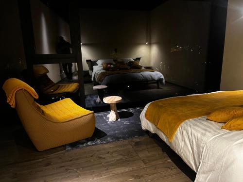 a bedroom with two beds and a chair and a table at Séneçon des bois 08 in La-Roche-en-Ardenne