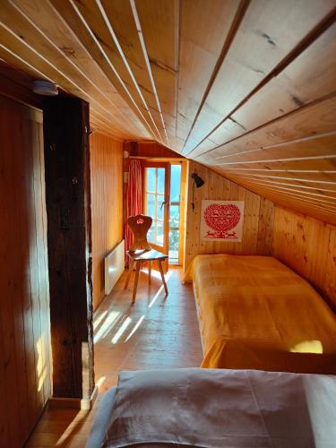 a bedroom with a bed and a chair in it at Mazot de l' Arche de Noé in Verbier