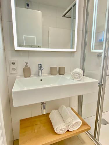 a bathroom with a sink and a mirror and towels at Grimming View I - Zentral in Tauplitz, Nahe Sessellift, Bergblick & Parkplatz in Tauplitz