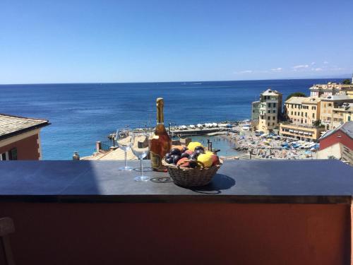 una cesta de fruta y una botella de vino en una cornisa en La Mansarda Sul Mare en Bogliasco