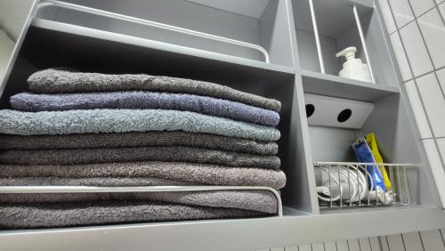 Un montón de toallas están dispuestas en un armario en West Ocean View of Nick's home, en Toran-mal