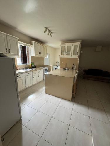 Una cocina grande con gabinetes blancos y una isla grande. en St Lucie Suite, en Monchy