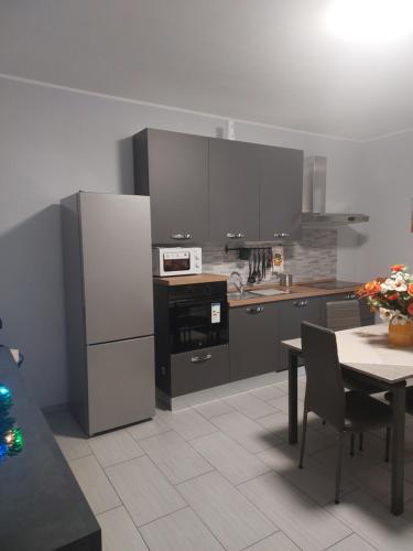 Una cocina con electrodomésticos de acero inoxidable y una mesa con un tableablish en Girasole, en Alessandria