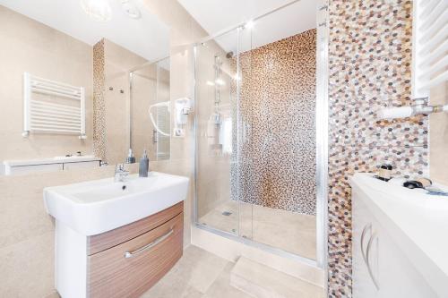 a bathroom with a shower and a sink and a shower at Six Suites, Old Town in Gdańsk