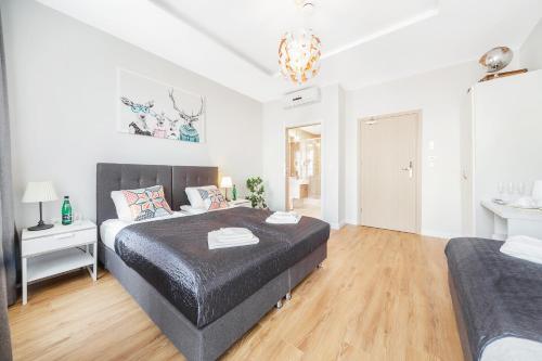 a bedroom with a large bed and a white room at Six Suites, Old Town in Gdańsk