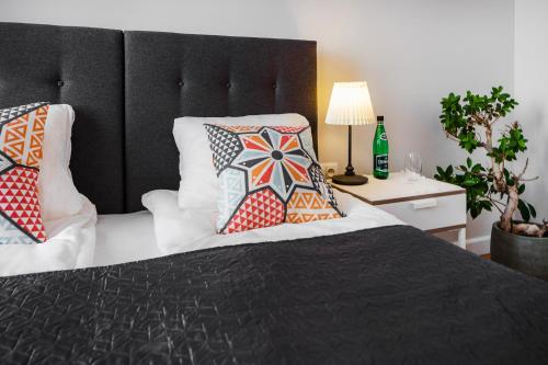 a bedroom with a black bed with pillows on it at Six Suites, Old Town in Gdańsk