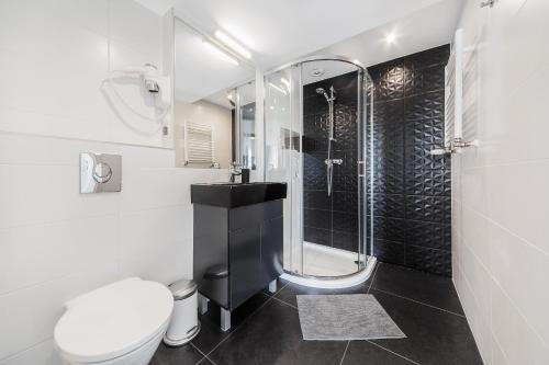 a bathroom with a toilet and a sink and a shower at Six Suites, Old Town in Gdańsk