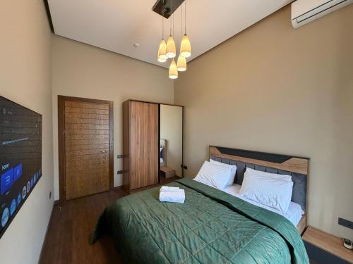 una camera da letto con un letto grande con una coperta verde di Premium suite a Baku