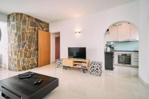 a living room with a tv and a kitchen at Casa Beatriz in Carvoeiro