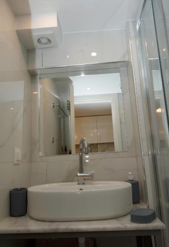a bathroom with a sink and a mirror at IFI Apartments in Paralia Katerinis