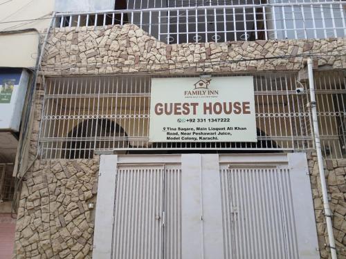 a guest house sign on the side of a building at Family Inn Guest House in Karachi
