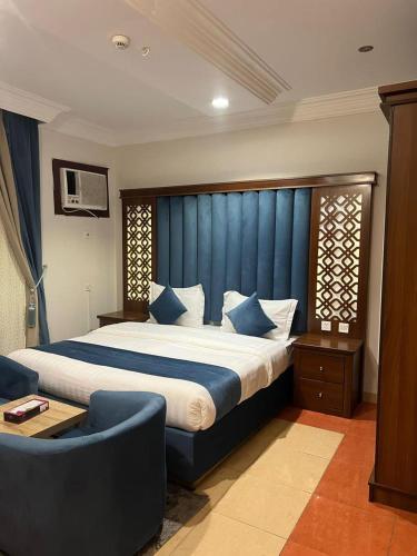 a bedroom with a large bed with a blue headboard at Distinctive Palace - القصصر المميز للشقق المفروشه in Abha