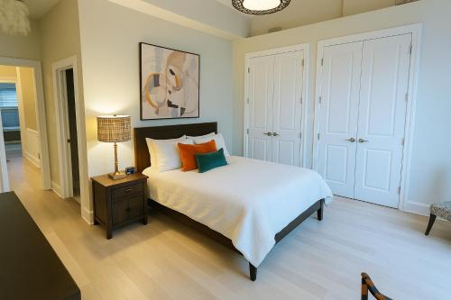a bedroom with a bed with white sheets and orange pillows at Modern 1 block from Metro subway Minutes to Capital, Museums and National Mall in Washington