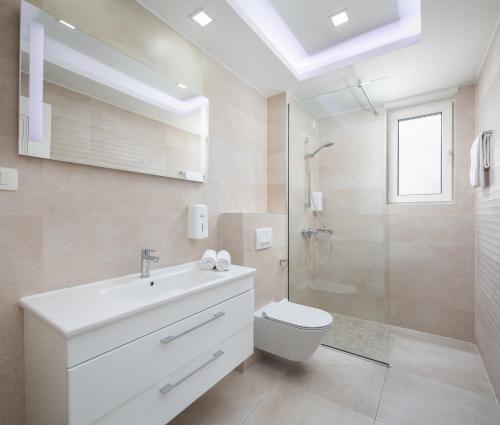 a bathroom with a sink and a toilet and a shower at Villa Jakov Apartments II in Promajna