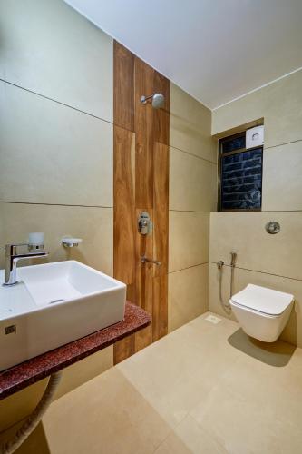 a bathroom with a sink and a toilet at Hotel Rajpurush in Kolhapur