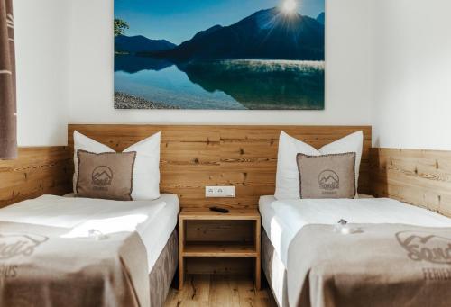 two beds in a room with a picture on the wall at Sandi`s Ferienhaus in Reutte