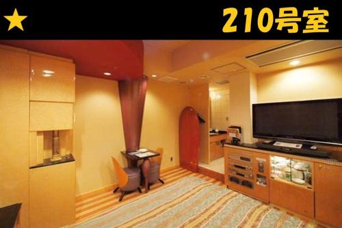 a living room with a flat screen tv and a living room at HOTEL Us Bentenbashi Adult only in Niigata