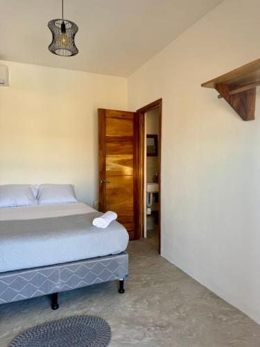 a bedroom with a bed and a wooden door at Secret Garden Cottage in El Naranjo