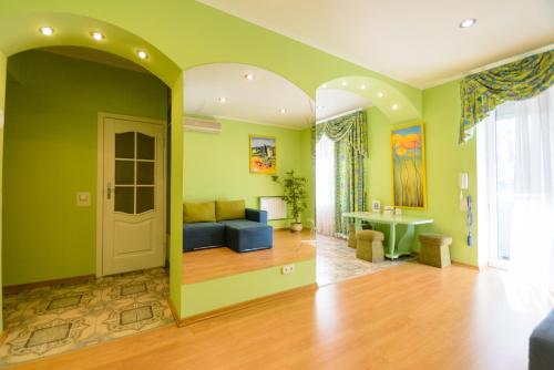 a living room with green walls and a blue couch at Partner Guest House Baseina in Kyiv