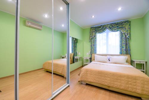 a green bedroom with two beds and a window at Partner Guest House Baseina in Kyiv