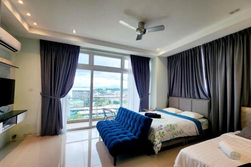 a bedroom with a blue couch in front of a window at Riverine Cozzy Resort RDA in Kuching
