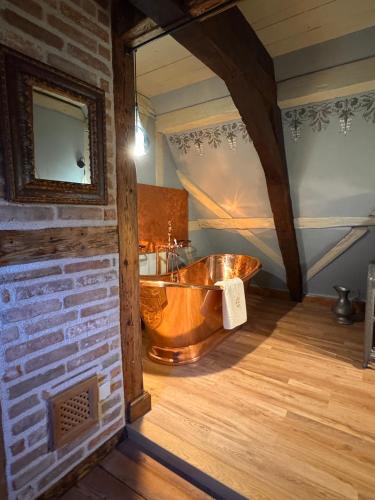 a bathroom with a copper tub in a room at Le Domaine de l Ill Domaine patrimonial unique en Alsace in Fislis