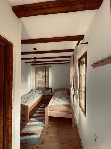 a room with two beds and a staircase in a house at Dobál vendégház in Lunca de Sus