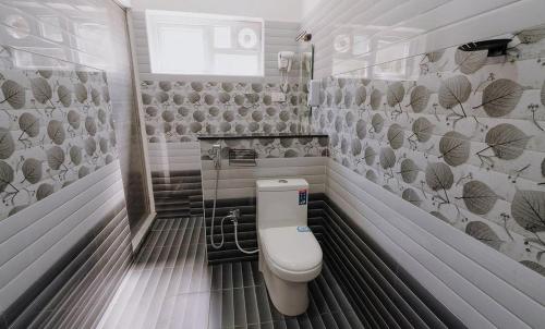 a bathroom with a toilet in a room at Prithivee Homestay in Kotagiri