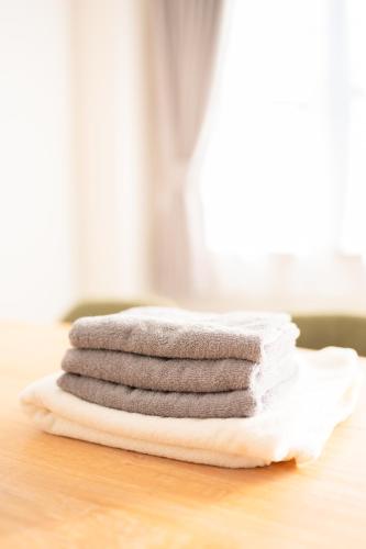 a stack of towels sitting on top of a table at 一棟貸切りNagoya west2 in Nishi-biwajima