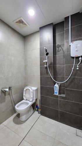 a bathroom with a toilet and a shower at Riverine Cozzy Resort RDA in Kuching