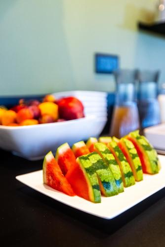 un plato de fruta en una mesa con un bol de fruta en Hôtel Pont Rouge , Carcassonne, en Carcassonne