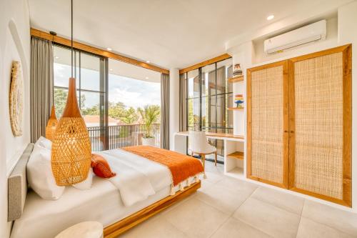 a bedroom with a large bed and a balcony at Senada Garden in Uluwatu