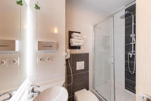 Un baño con ducha, lavabo e inodoro. en Hôtel Pont Rouge , Carcassonne, en Carcassonne