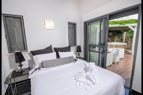 Black&White Had Ness في هاد نيس: غرفة نوم مع سرير أبيض كبير وشرفة