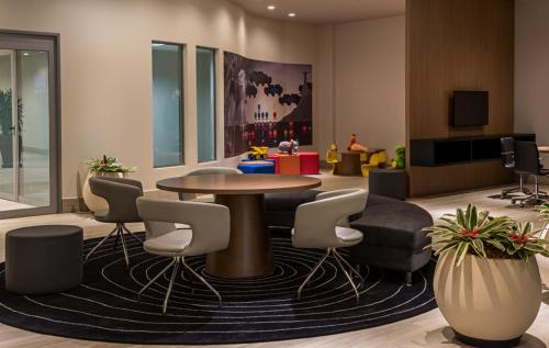 a lobby with a table and chairs and a tv at Novotel RJ Praia de Botafogo in Rio de Janeiro