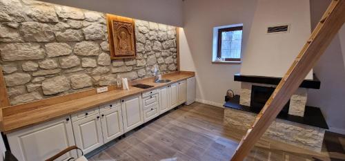 eine Küche mit einer Steinmauer und einem Waschbecken in der Unterkunft Planinska kuća 