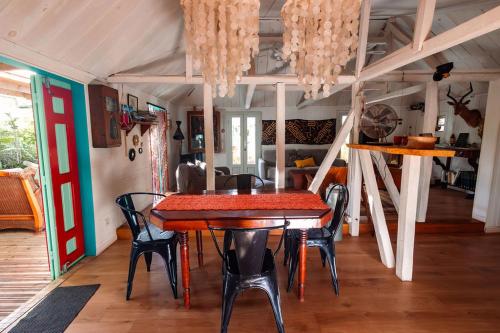 a dining room with a table and chairs at L'incroyable maison de Mamie MECHANT in Saint-Philippe