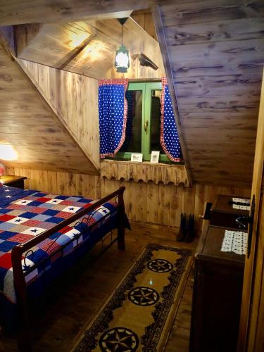 a bedroom with a bed in a room with wooden walls at Domek Kowboja in Iława