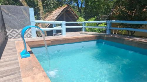 uma piscina rasa com mangueira no quintal em Pousada Recanto do Beija Flor em São José dos Pinhais