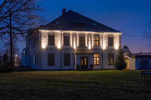 een wit huis met 's nachts verlichting bij Resort Červený dvůr - apartmány a privátní wellness in Rapotín