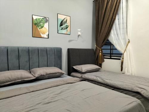 Un dormitorio con dos camas y una ventana. en Room&Rest Homestay Seremban Mutiara Galla, en Seremban