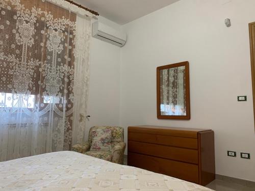 ein Schlafzimmer mit einem Bett, einer Kommode und einem Spiegel in der Unterkunft Vacanze nel cuore del Salento in Galatone
