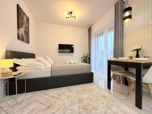 a bedroom with a bed and a table and a desk at Apartament Natura in Piła