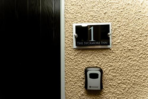 a sign on the side of a wall with a cell phone at The Sycamore Inn in Birch Vale